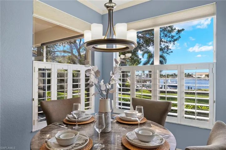 Dining space featuring a water view, crown molding, and a chandelier