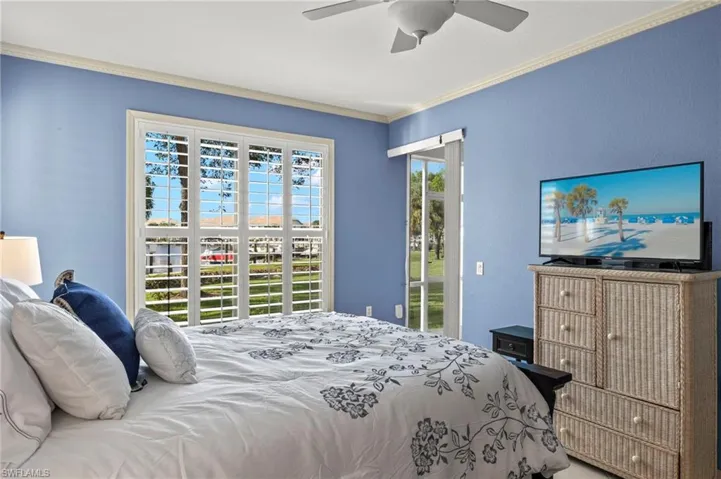 Bedroom featuring ceiling fan, access to exterior, and crown molding