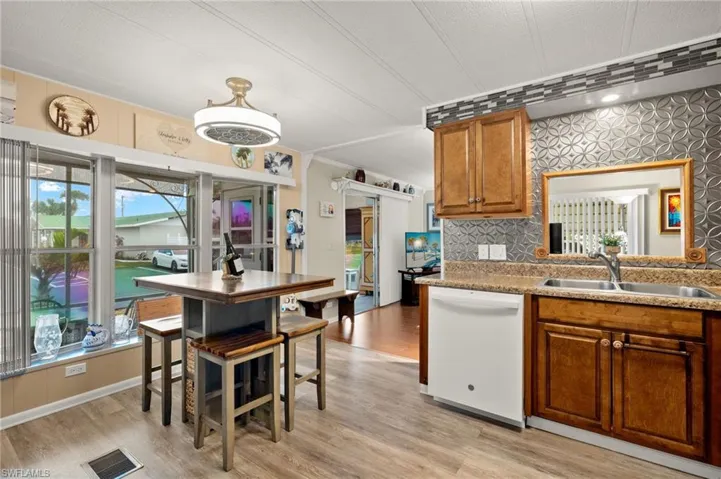 Kitchen featuring brown cabinets, dishwasher, tasteful backsplash