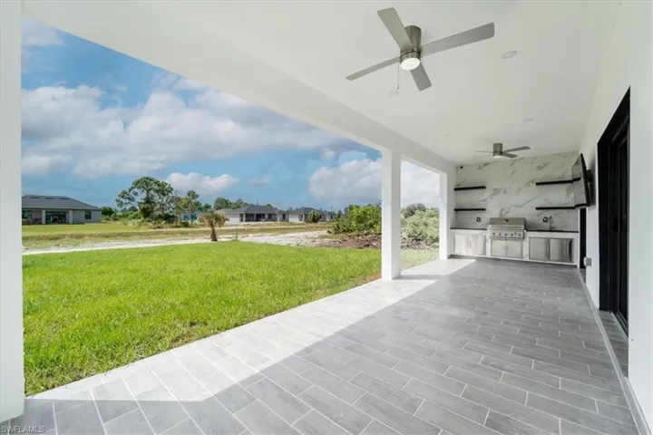 View of patio / terrace with exterior kitchen, ceiling fan, and a residential view