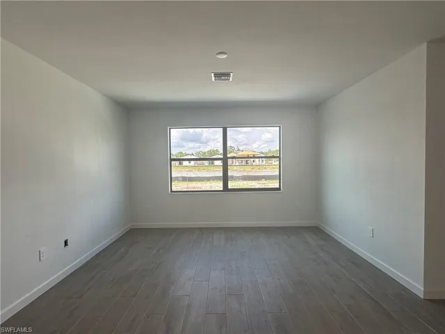 Empty room featuring dark hardwood / wood-style floors