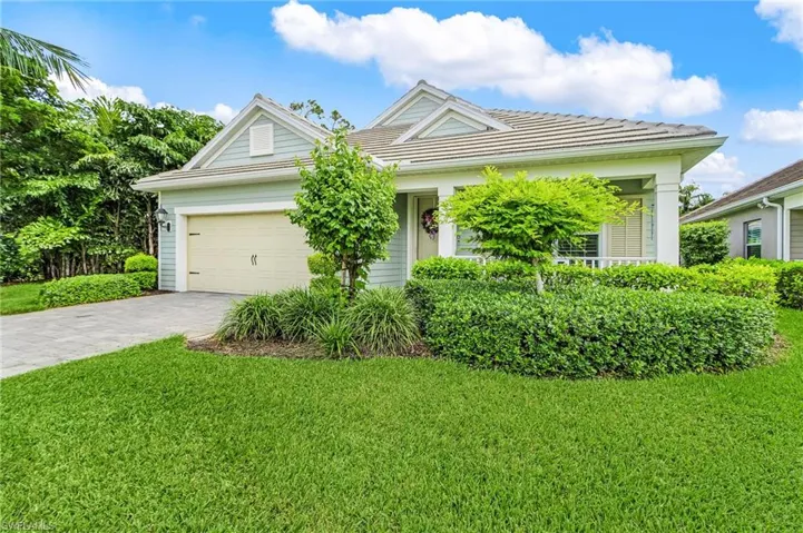 Single story home featuring decorative driveway, an attached garage, and a front lawn