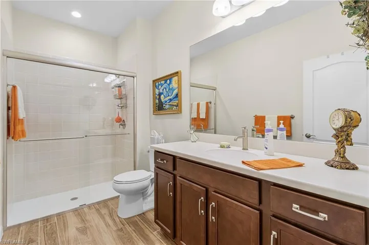 Bathroom with light wood-style floors, vanity, and a stall shower
