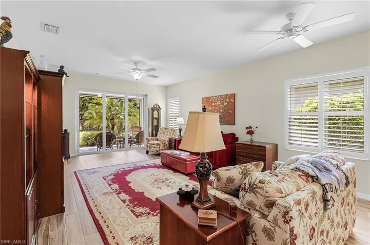 Living area with ceiling fan and light wood-style flooring