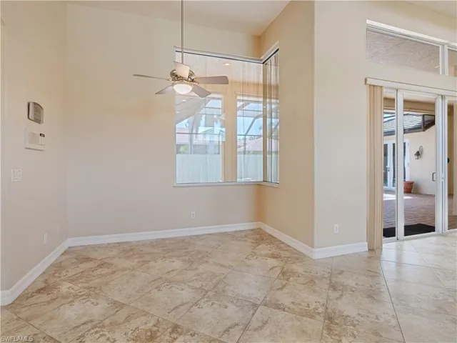 Tiled spare room featuring ceiling fan