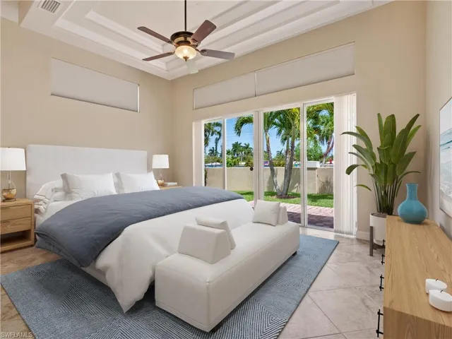 Tiled bedroom featuring a raised ceiling, access to outside, and ceiling fan