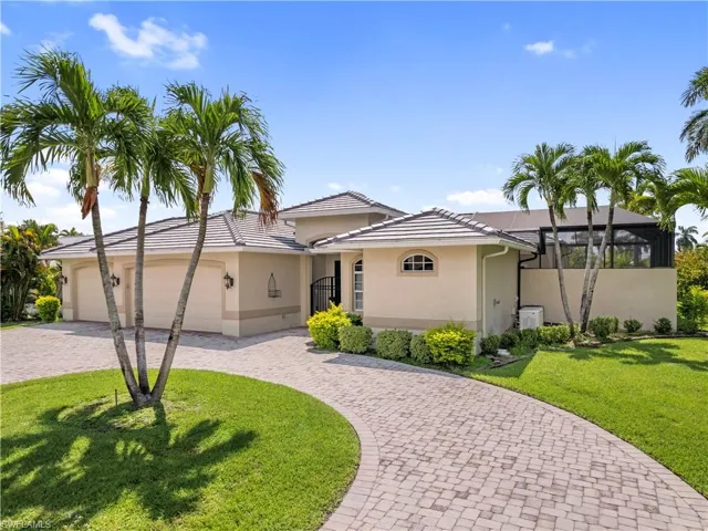 View of front of property featuring a garage, cooling unit, and a front lawn