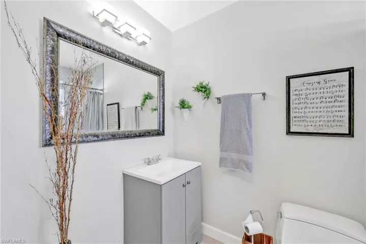 Full bath featuring toilet, vanity, and baseboards