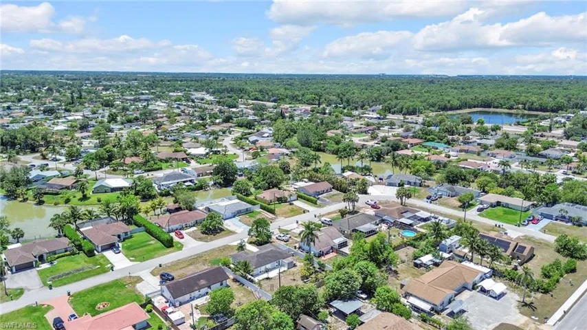 View of property location with nearby suburban area, a large body of water, and a forest