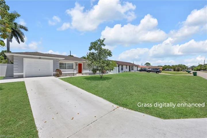 Ranch-style home with concrete driveway, a garage, and a front lawn