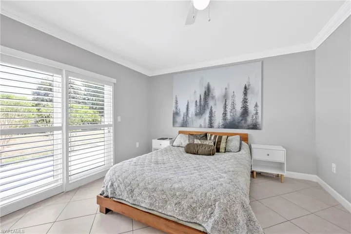 Bedroom with light tile patterned flooring, ornamental molding, access to exterior, baseboards, and ceiling fan