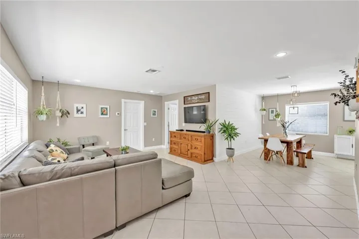 Living room with baseboards, light tile patterned flooring, and recessed lighting
