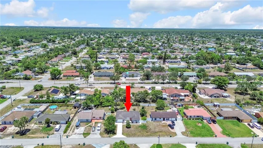 Aerial view of property and surrounding area featuring nearby suburban area