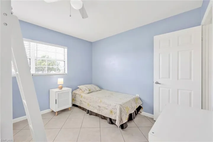 Bedroom with baseboards, a ceiling fan, and light tile patterned floors