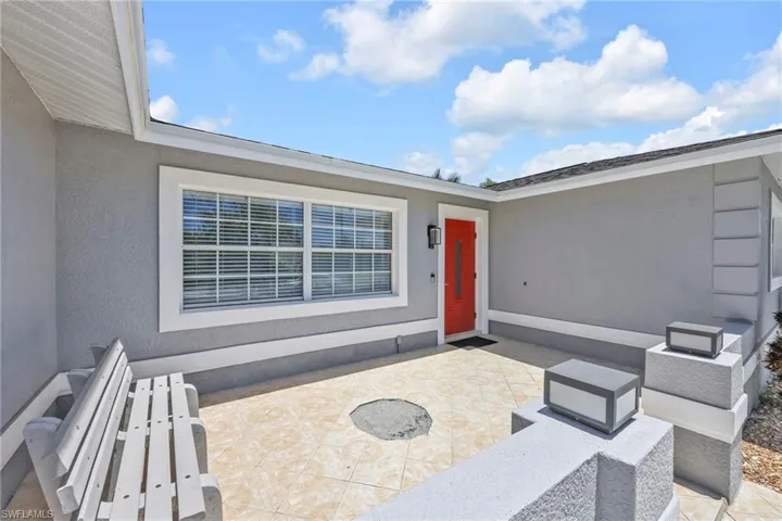View of exterior entry featuring stucco siding and a patio area