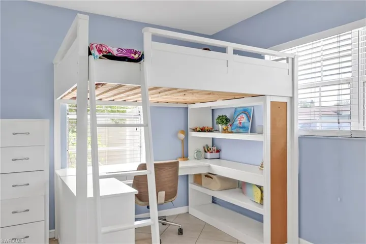 Bedroom featuring a desk, multiple windows, tile patterned flooring, and baseboards
