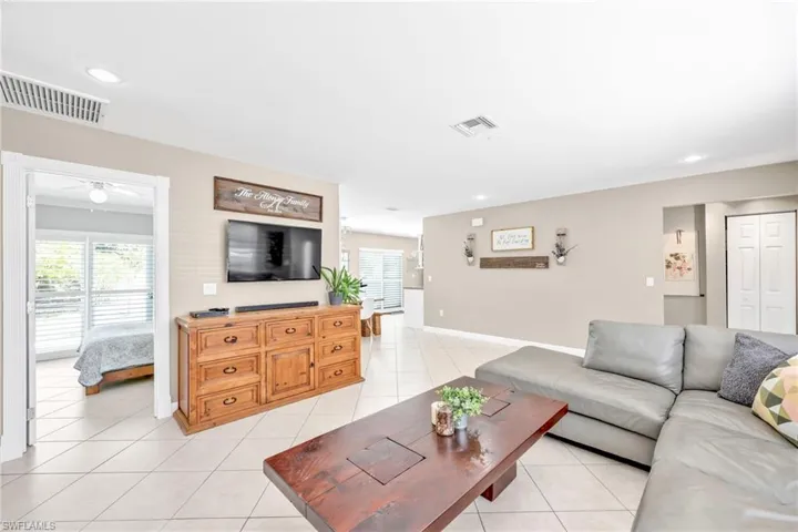 Living room featuring plenty of natural light, light tile patterned flooring, a ceiling fan, recessed lighting, and baseboards