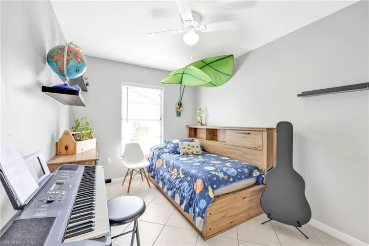 Tiled bedroom with baseboards and a ceiling fan