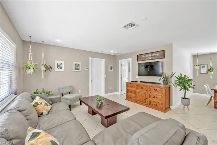 Living area with light tile patterned floors, plenty of natural light, baseboards, and recessed lighting