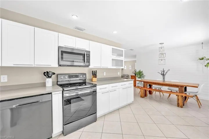Kitchen with appliances with stainless steel finishes, white cabinetry, light countertops, and recessed lighting
