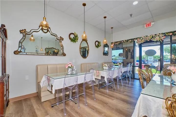 Dining room featuring wood finished floors, a paneled ceiling, and baseboards