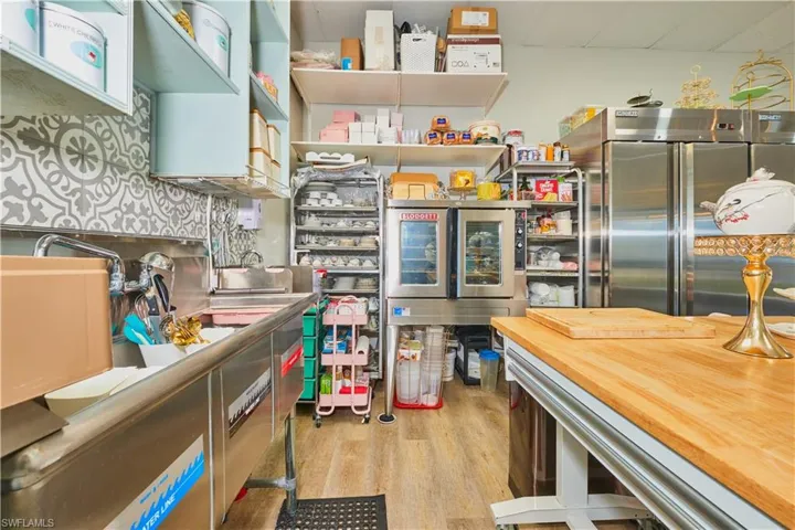 Kitchen with stainless steel built in refrigerator, light wood finished floors, and butcher block countertops