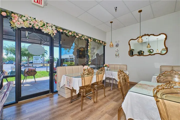 Dining room featuring a drop ceiling, wood finished floors, and baseboards