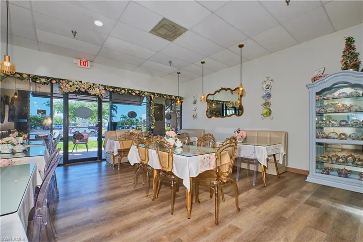 Dining space with a drop ceiling, wood finished floors, and baseboards