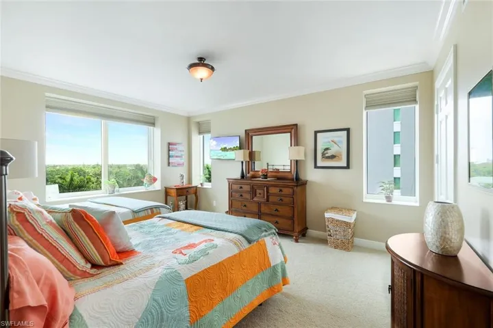 Carpeted bedroom with ornamental molding