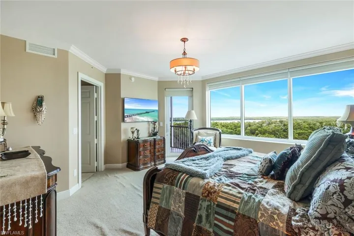 Bedroom with crown molding and inviting chandelier