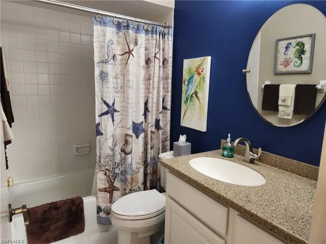 Full bathroom featuring tile flooring, shower / bath combo, toilet, and vanity