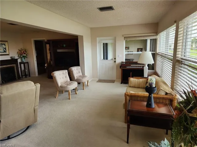 Carpeted living room with a textured ceiling