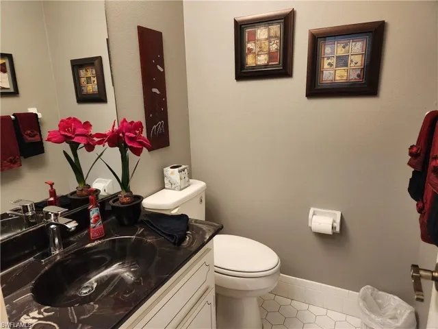 Bathroom with tile flooring, oversized vanity, and toilet