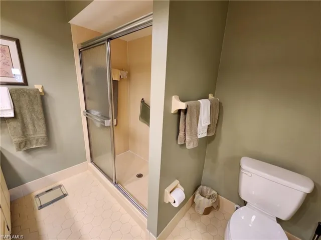 Bathroom with tile floors, walk in shower, and toilet