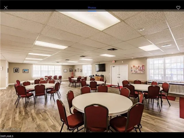 Dining space with hardwood / wood-style floors and a drop ceiling