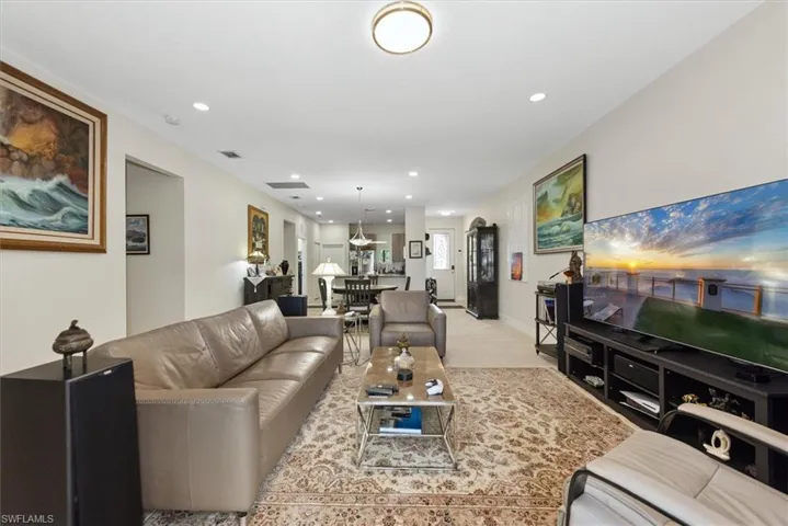 Spacious living area featuring light-toned walls, recessed lighting, and a neutral-toned ceiling