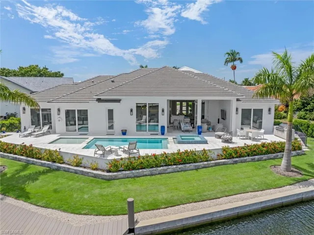 Rear view of property with a patio, a swimming pool with hot tub, and a yard