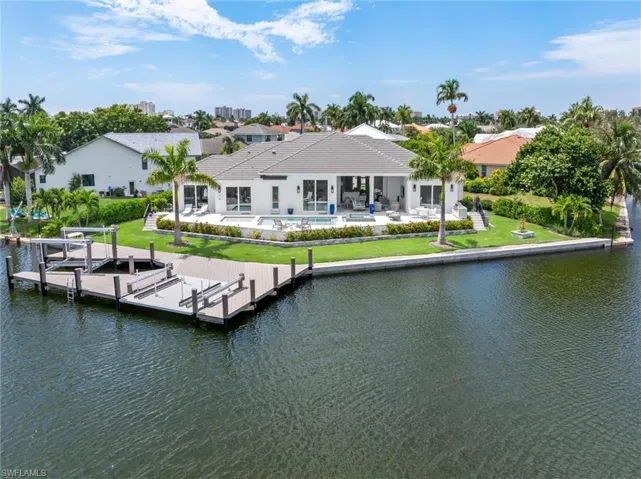 Dock area featuring a patio, a water view, a swimming pool, and a yard