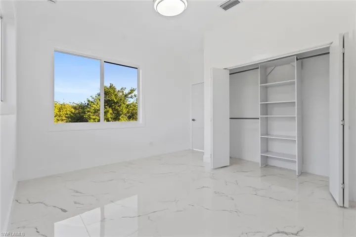 Master bedroom featuring light marble finish flooring and a closet
