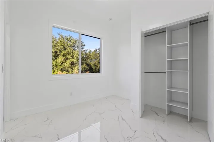 2nd Bedroom with light marble finish flooring and a closet