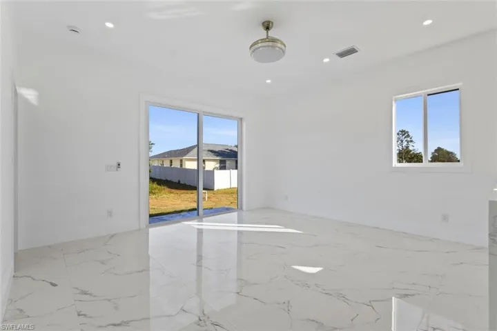 Living Room and Dining Room with plenty of natural light, light marble finish floors, and recessed lighting