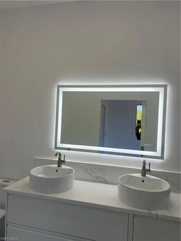 Bathroom with double vanity and a textured wall