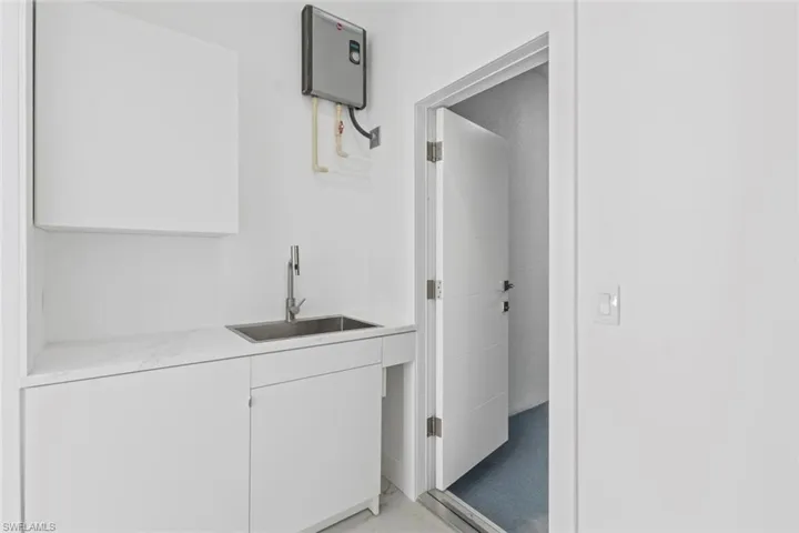 Laundry room with sink and cabinets.