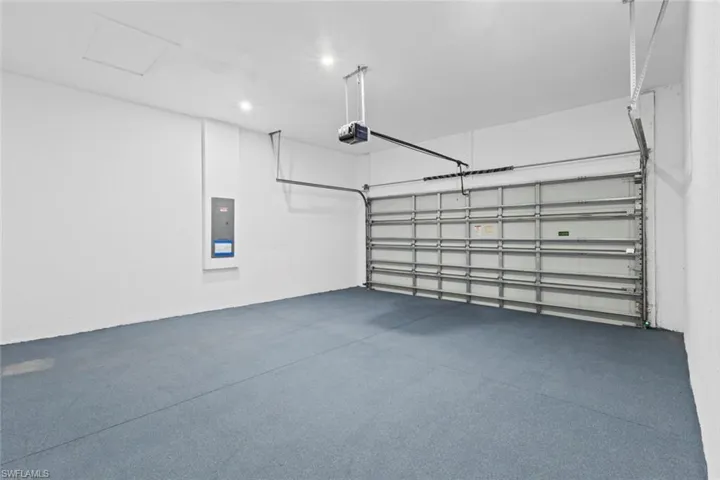 Garage with electric panel and a garage door opener