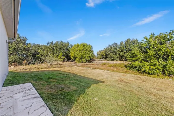 View of green lawn with a rural view