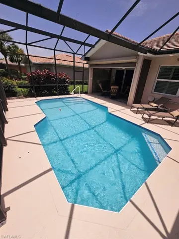 Swimming pool featuring a patio area, a lanai, and a sunroom