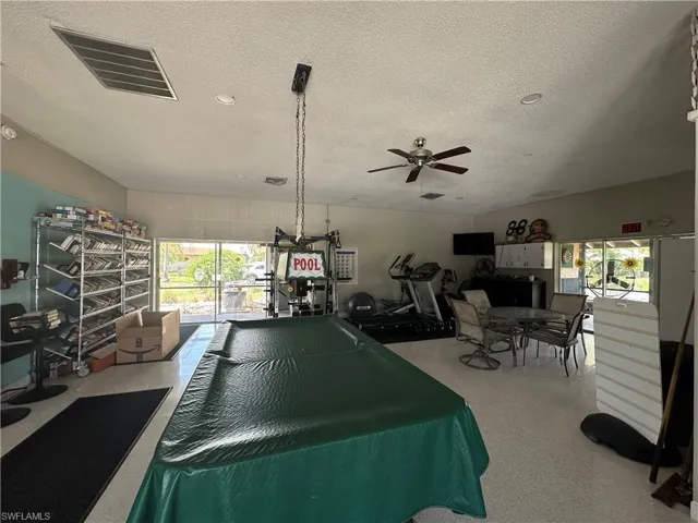 room with pool table, exercise equipment, books, etc.