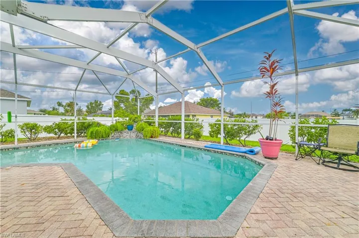 View of pool featuring glass enclosure and a patio