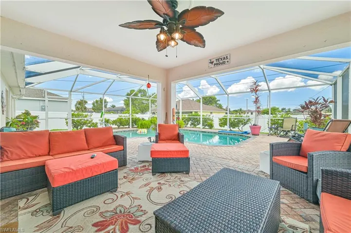 View of patio with ceiling fan, glass enclosure, and outdoor lounge area