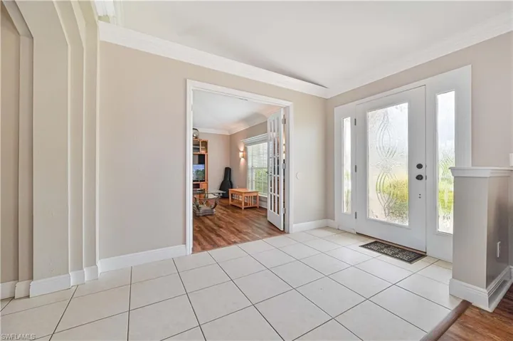 Entryway with light hardwood / wood-style floors and ornamental molding